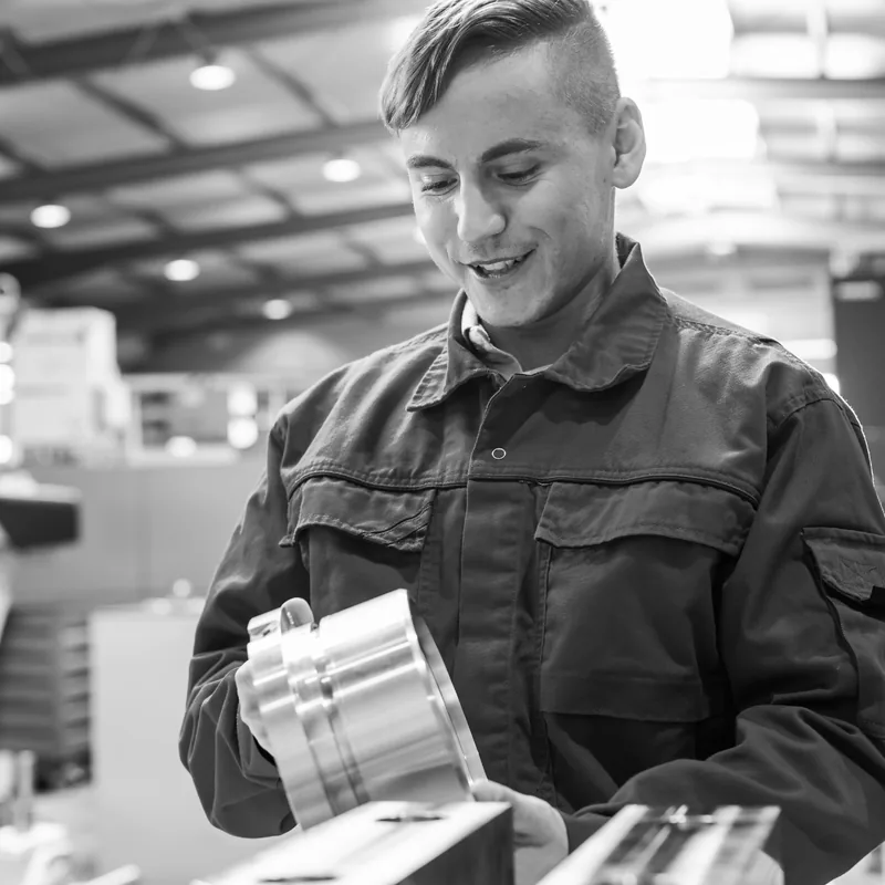 Auszubildender prüft ein Werkstück in der Metallbearbeitung